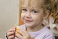 The little girl with enthusiasm and eats a roll with pleasure