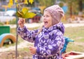 The little girl with enthusiasm shows leaves