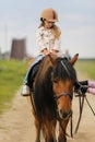 Little girl in an equestrian helmet riding a horse. Girl on a horse walk in nature