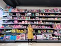 Budva, Montenegro - 13 august 2023: Little girl examines colorful dolls on the supermarket shelves