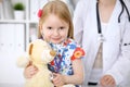 Little girl examining her Teddy bear by stethoscope. Health care, child-patient trust concept. Royalty Free Stock Photo