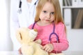 Little girl examining her Teddy bear by stethoscope. Health care, child-patient trust concept. Royalty Free Stock Photo