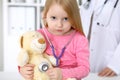 Little girl examining her Teddy bear by stethoscope. Health care, child-patient trust concept. Royalty Free Stock Photo