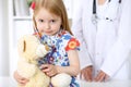 Little girl examining her Teddy bear by stethoscope. Health care, child-patient trust concept. Royalty Free Stock Photo