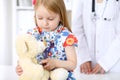 Little girl examining her Teddy bear by stethoscope. Health care, child-patient trust concept. Royalty Free Stock Photo