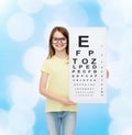 Little girl in eyeglasses with eye checking chart Royalty Free Stock Photo