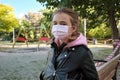 Little girl in face mask near playground fenced off with warning tape Royalty Free Stock Photo