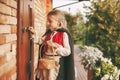 Little girl in a fairy costume with a basket in her hands is knocking on the door during the Halloween celebration Royalty Free Stock Photo