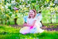 Little girl in fairy costume feeding a bird Royalty Free Stock Photo