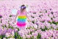 Little girl in fairy costume playing in flower field Royalty Free Stock Photo