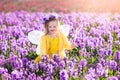 Little girl in fairy costume playing in flower field Royalty Free Stock Photo