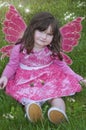 Little girl with fairy wings, pink dress and sparks of light