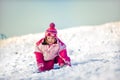 Little girl falling down in snow