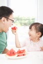 little girl with father eating fruits