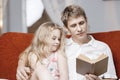 Little girl and father are enjoying reading book together.