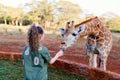 Cute little girl feeding giraffes in Africa Royalty Free Stock Photo