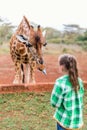 Cute little girl feeding giraffes in Africa Royalty Free Stock Photo