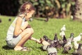 Little girl feeding pigeons in the park Royalty Free Stock Photo