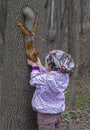 Little girl feeds a squirrel.