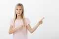 Little girl feeling intense pointing at friend who did mess in classroom during break. Awkward adorable child with blond