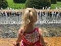 Little girl with feet in a fountain on hot day Royalty Free Stock Photo