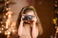 little girl in a festive dress with flowing hair takes pictures on a vintage camera Royalty Free Stock Photo