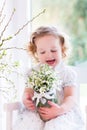Little girl with first spring flowers at home Royalty Free Stock Photo