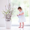 Little girl with first spring flowers at home Royalty Free Stock Photo