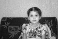 Little girl five old year of beautiful dress, sit on sofa. Black and white. Royalty Free Stock Photo