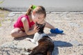 Little girl holding head of a cat sitting on the ground