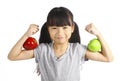 A little girl flexes her muscle while showing off the apple that made her strong and healthy