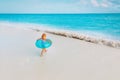 Little girl with floatie go to swim on tropical beach Royalty Free Stock Photo