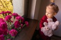 The little girl with flowers on the window Royalty Free Stock Photo