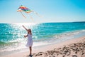 Little girl flying a kite on beach at sunset Royalty Free Stock Photo