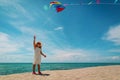 Little girl flying a kite at sky on beach Royalty Free Stock Photo