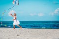 Little girl flying a kite at sky on beach Royalty Free Stock Photo
