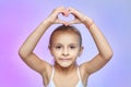 The little girl folded her hands in the shape of a heart Royalty Free Stock Photo