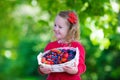 Little girl with fresh berries in a basket Royalty Free Stock Photo