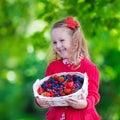 Little girl with fresh berries in a basket Royalty Free Stock Photo