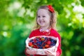 Little girl with fresh berries in a basket Royalty Free Stock Photo