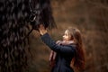 Girl with friesian horse autumn forest