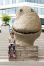 Little girl and funny sculpture on the stairs at Aker Brygge, Oslo, Norway