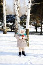 Little girl in a fur coat and fluffy Orenburg shawls with an app