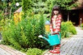 Little girl in a garden with green watering can Royalty Free Stock Photo