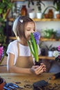 Little girl gardener plants hyacinth. Girl holding hyacinth in flower pot. Child taking care of plants. Royalty Free Stock Photo