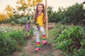 Little girl gardener in vegetables garden holding fresh biologic just harvested carrots and kohlrabi Royalty Free Stock Photo