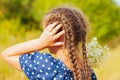 Little girl gathers a bouquet of wild flowers on a summer day in the field, back Royalty Free Stock Photo