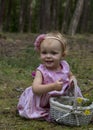 Little girl gathers flowers in the forest.