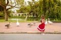 Little girl with geese in the park outdoors Royalty Free Stock Photo