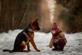 Little girl with German shepherd 6-th months puppy at early spring